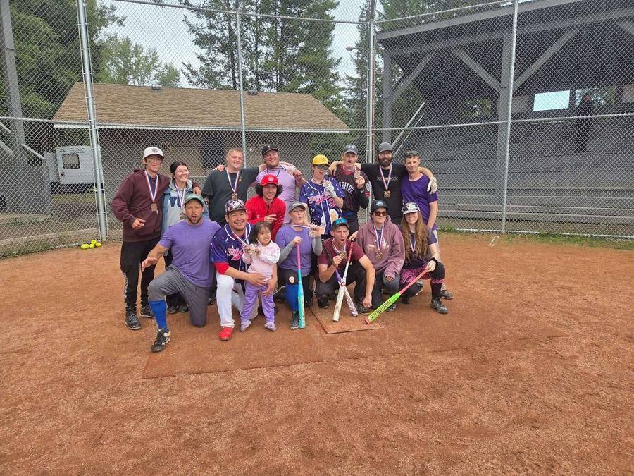A softball team with their medals after a tournament